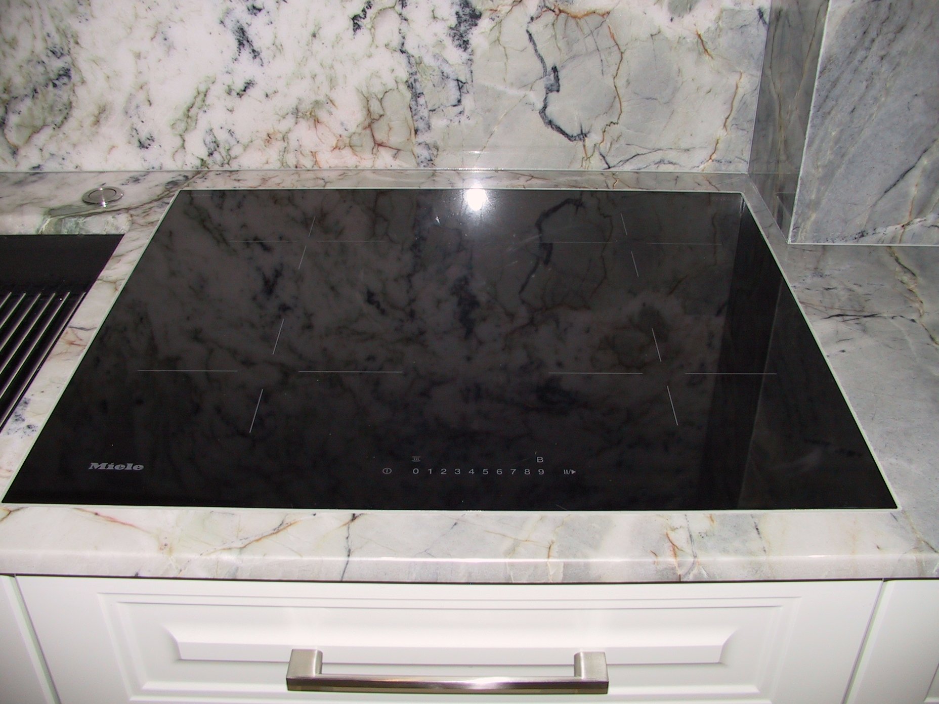 Jasny blat z naturalnego kwarcytu na tle jasnych mebli kuchennych